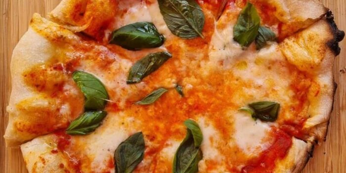 Italian Margherita pizza with tomato sauce, mozzarella, and basil leaves.
